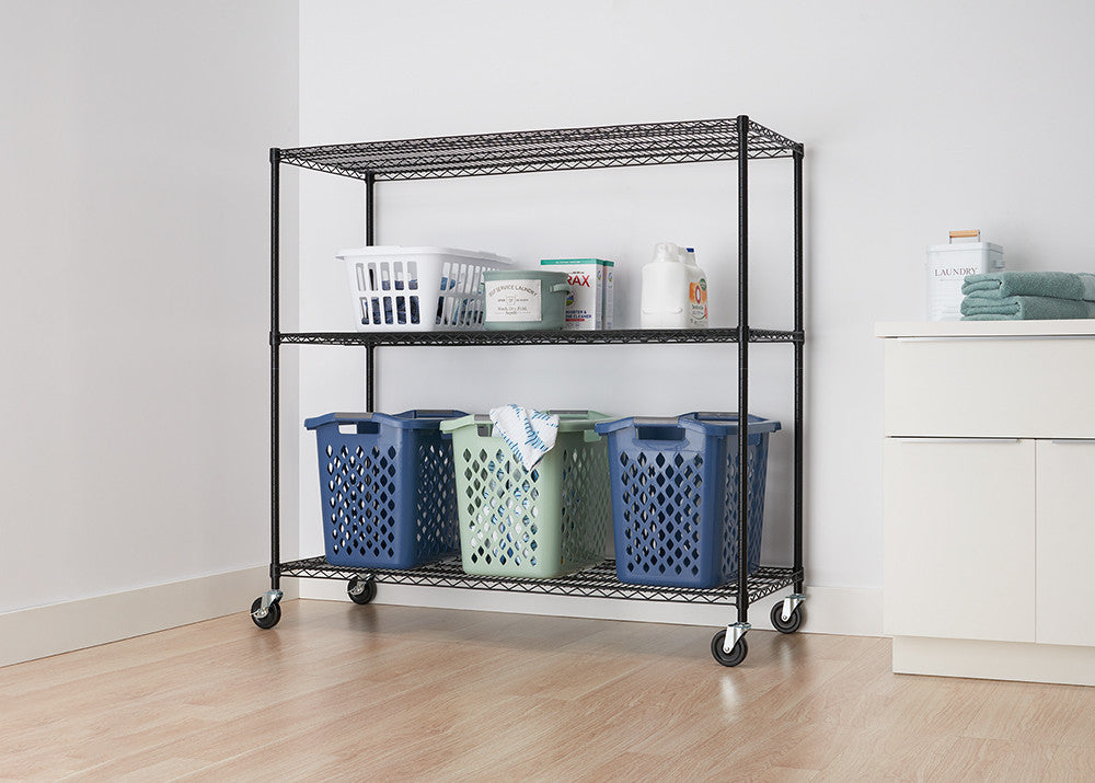 A black wire shelving unit with three tiers and wheels is positioned against a white wall. The shelves hold various laundry items, including baskets and detergent.