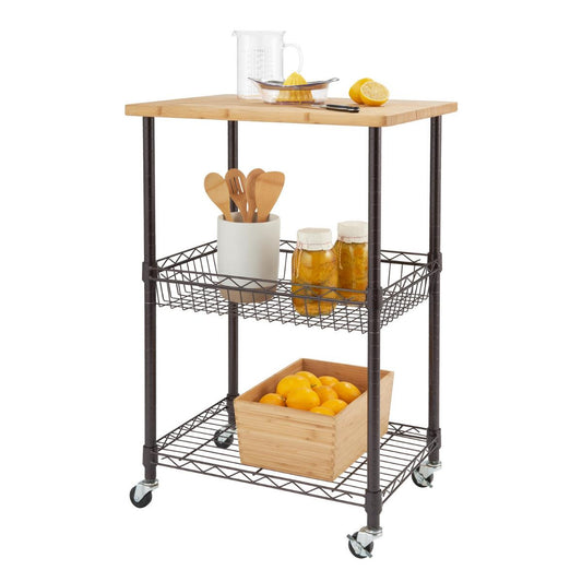 A three-tiered bronze kitchen cart with a light-colored wooden top, brown metal frame, and rolling wheels. The cart holds kitchen items such as wooden utensils, jars, and a basket of lemons.