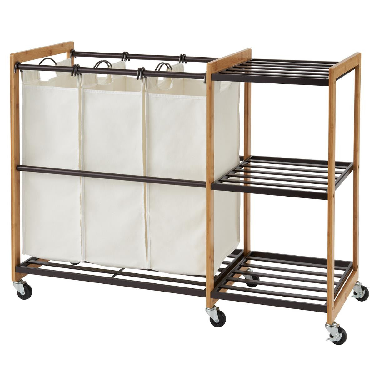 A bamboo and bronze metal laundry station features three cream-colored laundry bags hanging from a top rod. To the right, three slatted shelves provide additional storage, and the entire unit is on wheels.