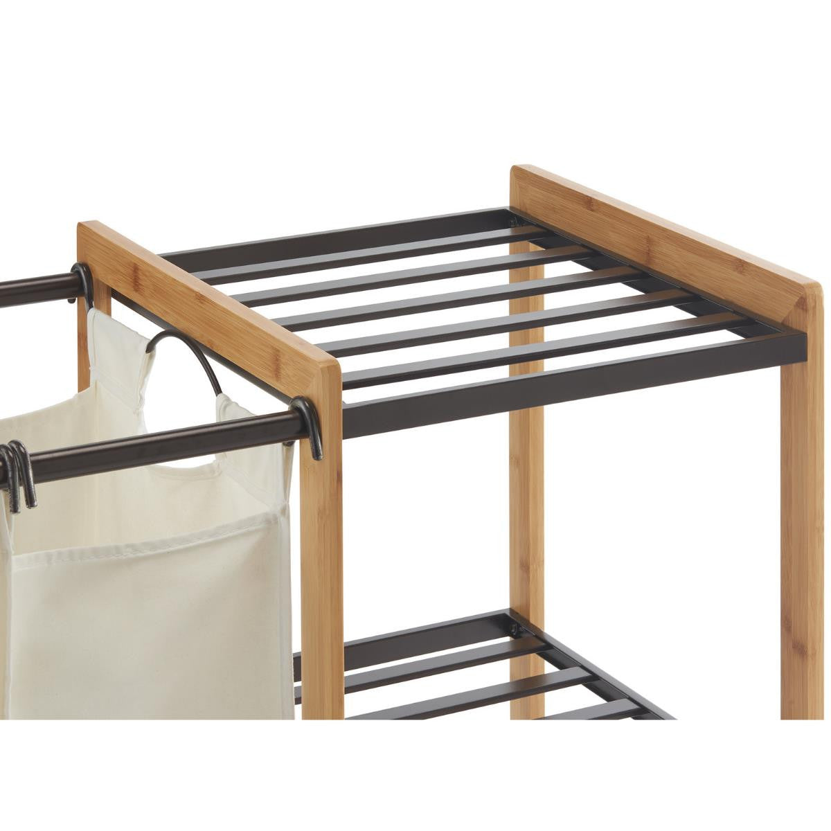 A close-up shot shows the upper section of a bamboo laundry sorter. It features a natural wood bamboo frame with bronze metal shelving and hanging rods, from which a light-colored fabric hamper is suspended on the left.