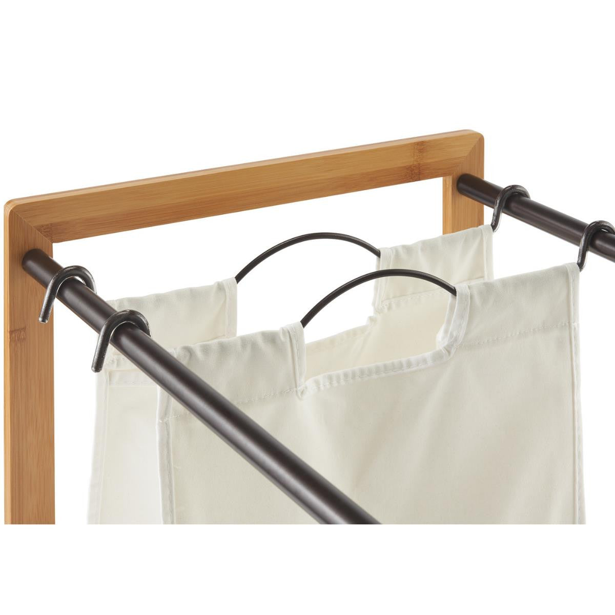 A close up of one of the laundry bags with removable metal handle. The rods are supported by a light brown bamboo frame, visible in the upper left and right corners.