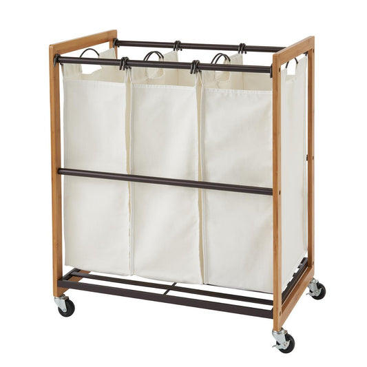 A bamboo laundry cart with 3 white cotton bags and bronze metal bottom shelf.  The sorter is on wheels, allowing for easy portability. 