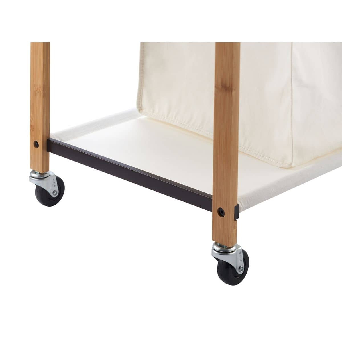 A close-up shows the bottom corner of a laundry cart. The cart features light brown bamboo legs, a black metal frame, and white caster wheels, with a glimpse of a white fabric laundry bag above.