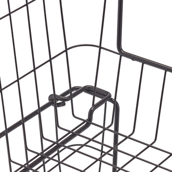 A close-up shot of the corner of a dark metal wire basket, highlighting the curved handle and the grid pattern of the wire. The handle's design shows a loop where it connects to the basket's side.