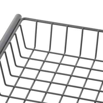 A close-up shot shows a gray, rectangular wire basket with a grid pattern at the bottom and vertical bars forming the sides. The smooth, rounded edge of the basket's rim is visible in the upper left corner.