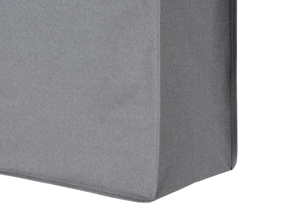 A close-up shot of a gray fabric-covered corner, likely part of a piece of furniture, showing the texture of the material and the seams. The fabric appears smooth and the corner is sharply defined.