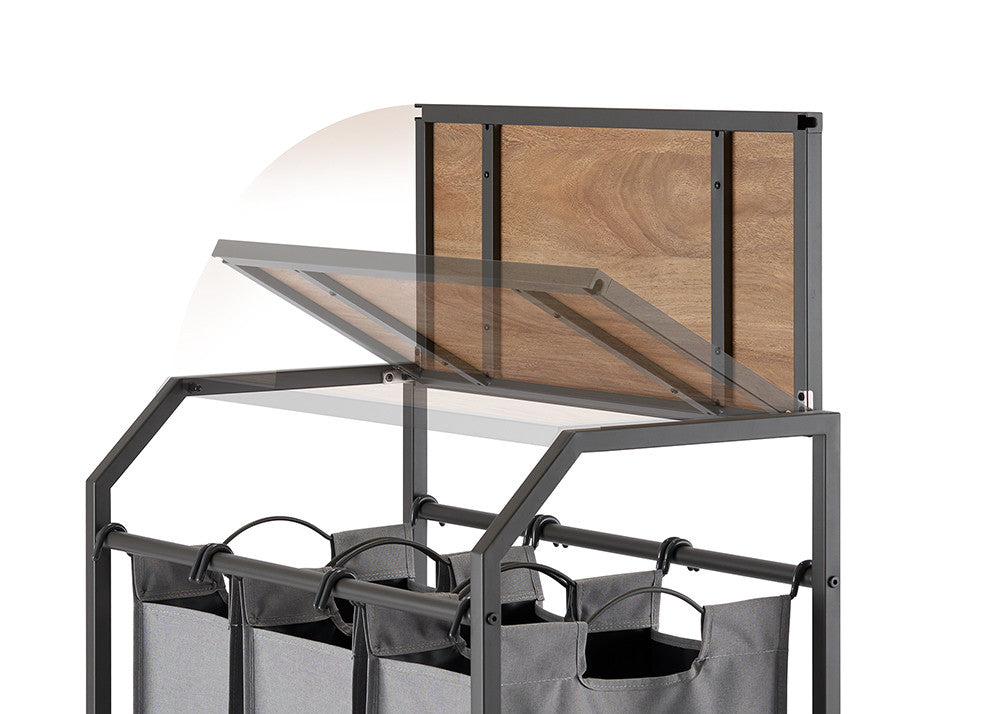 A close-up shot of a laundry cart with three gray fabric bags hanging below a metal frame. The cart features a flip-up wooden top, shown partially open with motion blur to indicate its hinged movement.