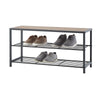 A dark gray, three-tiered shoe bench with wire shelves and a light brown wooden top is shown against a white background. Four pairs of shoes, in shades of brown and gray, are neatly arranged on the two lower shelves.