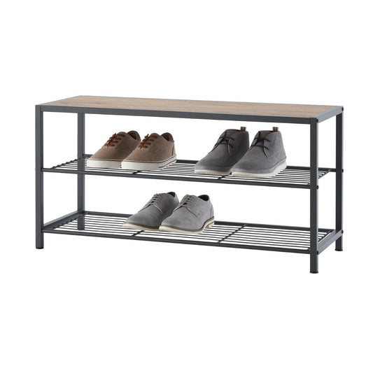 A dark gray, three-tiered shoe bench with wire shelves and a light brown wooden top is shown against a white background. Four pairs of shoes, in shades of brown and gray, are neatly arranged on the two lower shelves.