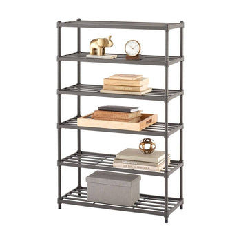 A tall, six-tier metal slat shelf unit stands against a white background. The shelves hold various household items, including books, decorative objects like a gold elephant and a small clock, and a gray fabric storage box on the bottom shelf.