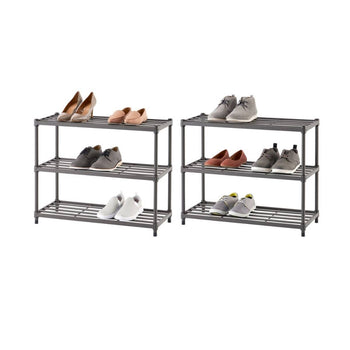 Two gray, three-tiered metal shoe racks stand side-by-side, each holding an assortment of shoes. The rack on the left displays three pairs of women's shoes, while the rack on the right holds three pairs of men's or unisex shoes.