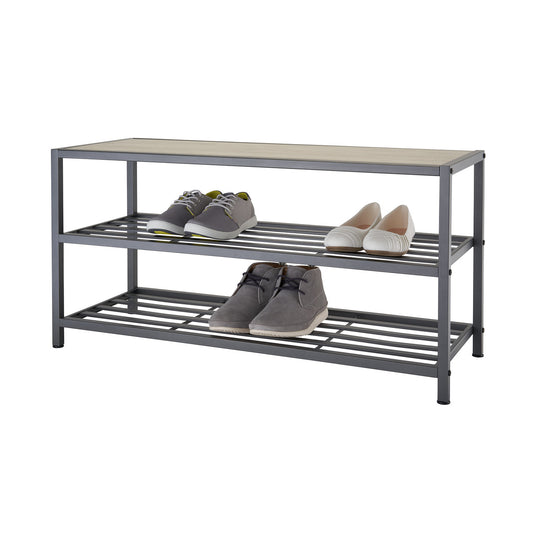 A three-tiered metal shoe rack with a light brown cushioned bench top holds several pairs of shoes. The bottom two tiers feature horizontal slats for shoe storage.