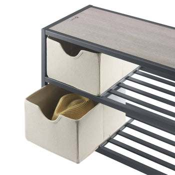 This close-up shot shows a corner of a three-tier shoe bench, featuring two light-colored fabric baskets on the upper tiers. A tan hat rests inside the lower basket, suggesting the baskets can be used for more than just shoes.