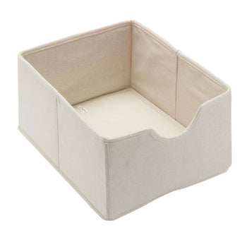 A cream-colored fabric storage bin is shown at a slight angle against a white background. The bin has a low, curved front, revealing the flat bottom inside.