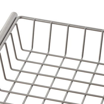 A close-up shot shows a section of a silver-colored wire basket with a grid pattern. The basket appears to be made of metal, possibly stainless steel, and is seen from a slightly elevated angle against a white background.