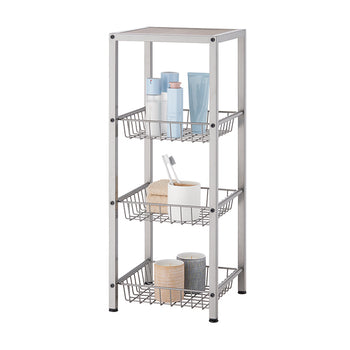A champagne colored, four-tier metal shelving unit with three slatted baskets is shown against a white background. The shelves hold various bathroom items, including lotions, a toothbrush, towels, and decorative candles.