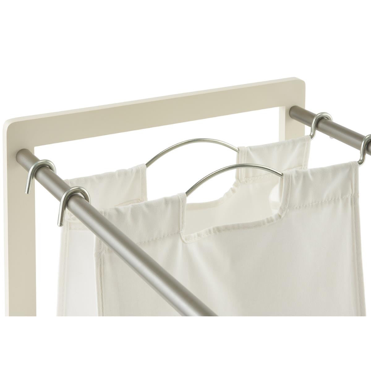 A close-up shot of a white laundry hamper with two of its three cloth bags visible. The bags are suspended by metal rods and hooks from a light-colored frame.