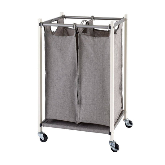 A white metal-framed laundry cart with two gray fabric bags is shown against a white background. The cart has four wheels for mobility.
