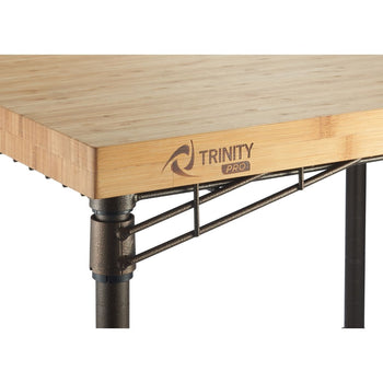 A close-up shot shows a portion of a Trinity Pro expandable bamboo top kitchen cart. The light-colored bamboo countertop features the 