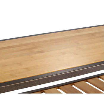 A close up of the bench wood top with bronze textured metal frame.