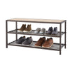 A three-tiered bronze anthracite metal shoe bench with a light brown wooden top displays various pairs of shoes. The bench has two lower grated shelves holding sneakers and dress shoes, while the top wooden surface is empty.