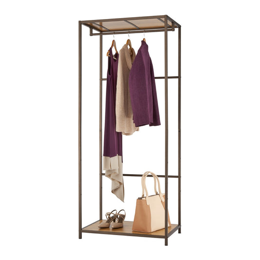 A bronze-colored metal garment rack stands against a white background, showcasing three hanging garments: a long purple dress, a light brown sweater, and a purple cardigan. Below, on a wooden shelf, are a pair of brown heeled sandals and a beige and brown tote bag.