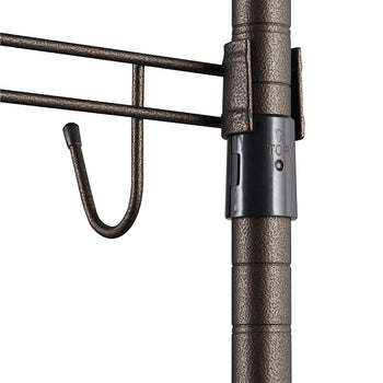 A close-up shows a section of a bronze-colored metal rolling garment rack. Visible are a vertical pole with circular grooves, a black plastic sleeve with a "TOP" arrow, and a horizontal bar with a hanging hook.