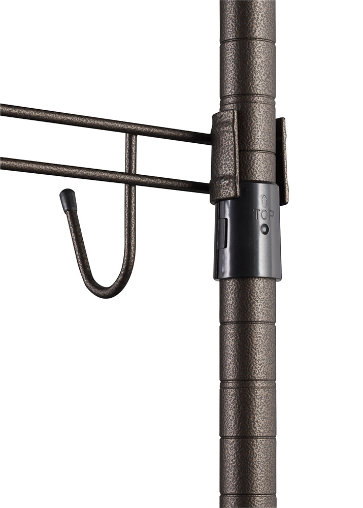 A close-up shows a section of a bronze-colored metal rolling garment rack. Visible are a vertical pole with circular grooves, a black plastic sleeve with a "TOP" arrow, and a horizontal bar with a hanging hook.