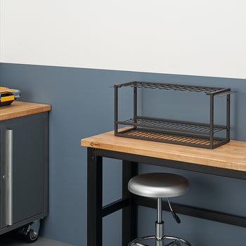 A workbench in a clean, organized garage or workshop. On the workbench sits a dark metal rack designed to hold tools, with an adjustable height stool tucked underneath.