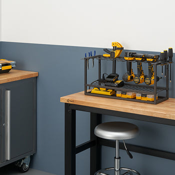 
A dark gray metal wire rack on a wooden workbench holds a collection of yellow and black power tools and accessories, including a sander and several drills. On the left, a matching rolling tool cabinet with a wooden top sits next to the workbench.