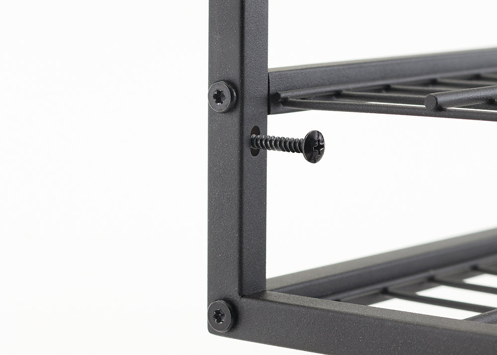 A close-up shot shows a black metal frame with a loose screw sticking out of a hole. The screw is a black self-tapping screw with a Phillips head, and another screw of the same type is fully inserted into the frame above it.