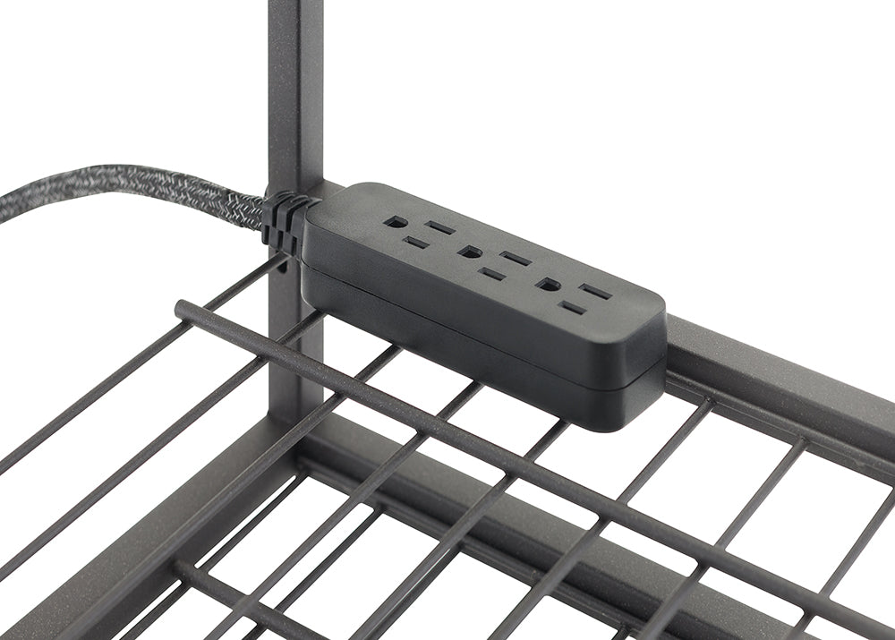 A black, rectangular power strip with three outlets is attached to the side of a metal wire shelf. The power strip's braided cord extends from the left, secured to the vertical metal frame with a tie.
