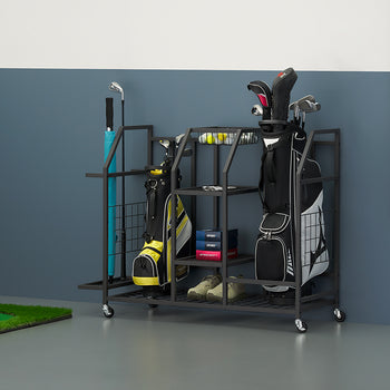 A black metal rolling storage cart holds golf equipment, including two bags, clubs, and shoes, against a grey wall. To the side, a putting green with a ball and flag is set up, complementing the scene of a organized personal golf garage or practice area.