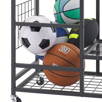 A close-up view of the bottom section of a black rolling sports cart against a white background. The metal rack is filled with various balls, including a basketball with '19' on it, a soccer ball, and other multi-colored balls, while caster wheels are visible on the legs.