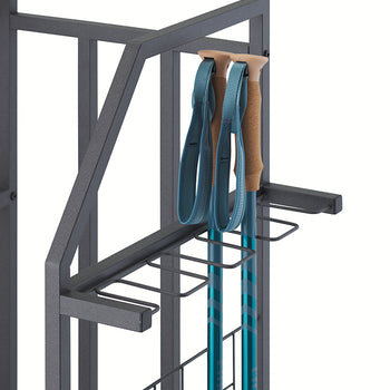 Two teal trekking poles with cork handles and blue wrist straps are stored in specialized wire slots on the side of a black metal organizer. The close-up showcases the rack's design for holding long, slim equipment securely against a white background.