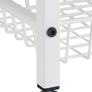 A close-up shot shows the bottom portion of a white metal shelf unit. The unit has a square leg with a black leveling foot at the bottom and a visible screw on its side, connecting it to a white wire basket shelf.