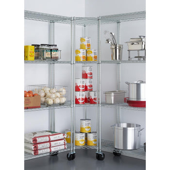 A shiny, chrome wire pantry shelving unit is set up in a corner, stocked with various kitchen supplies and canned goods. The shelves hold items like onions, canned fruits and vegetables, large sacks, cooking pots, and kitchen utensils, with the central corner unit featuring wheels for mobility.