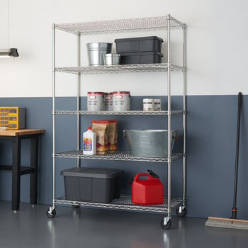 A tall, five-tier wire shelving unit on wheels is filled with various storage containers and items. The shelving unit is silver and stands against a two-toned wall, with a light gray upper portion and a dark blue lower portion.