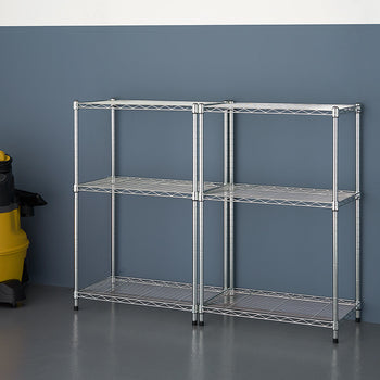 A metal shelving unit with two sections, each having three shelves, stands against a dark blue wall. A yellow and black wet/dry vacuum cleaner is to the left of the shelving unit.
