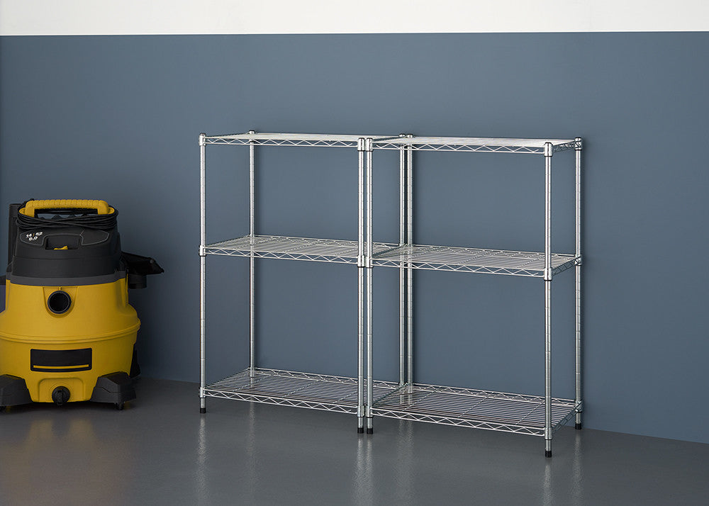A metal shelving unit with two sections, each having three shelves, stands against a dark blue wall. A yellow and black wet/dry vacuum cleaner is to the left of the shelving unit.