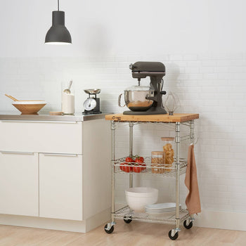 A Trinity Pro® EcoStorage® Expandable Bamboo Top Kitchen Cart. The cart is equipped with shelves and is placed in a kitchen setting.