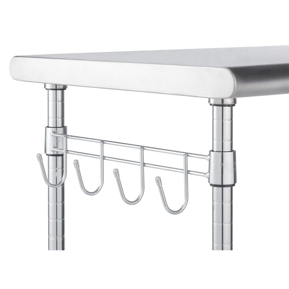 A close-up shows a section of a stainless steel service table. Visible are a portion of the top surface, two of the chrome-finished support poles, and a chrome wire rack with four hanging hooks attached to one of the poles.