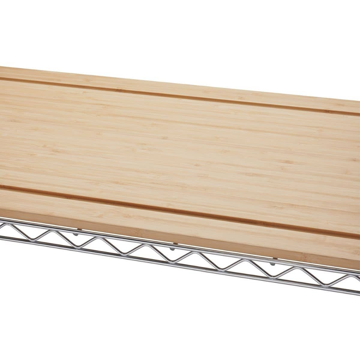 A close-up shows the top section of a Trinity Traditional Ecostorage Chrome Steel Bamboo Bakers Rack. The image highlights the light-colored bamboo countertop resting on the chrome wire shelving.