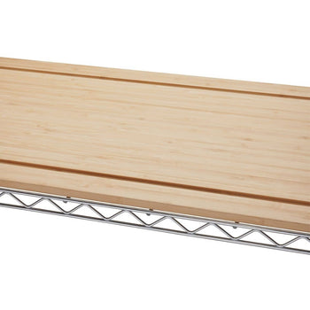 A close-up shows the top section of a Trinity Traditional Ecostorage Chrome Steel Bamboo Bakers Rack. The image highlights the light-colored bamboo countertop resting on the chrome wire shelving.