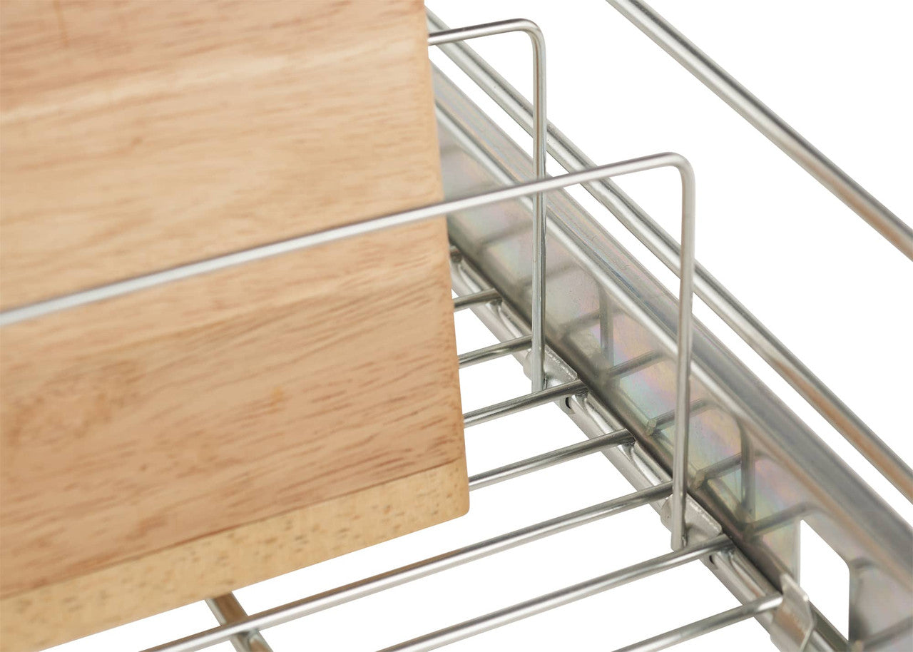 A close-up shows a portion of a silver, sliding wire drawer. A light brown wooden cutting board rests inside the drawer, leaning against the wireframe.