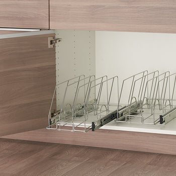 A partially open light brown cabinet reveals a white interior with two sliding wire racks designed to hold bakeware. Each rack features vertical wire dividers to keep items separated and organized.