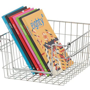 A silver wire basket filled with several colorful magazines titled 