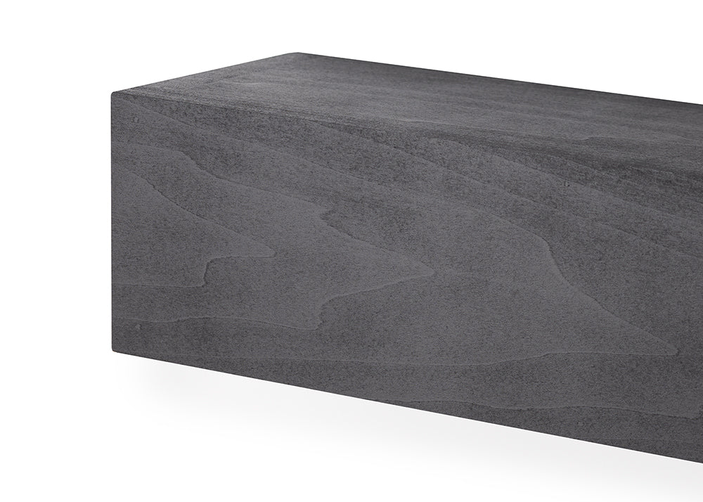 A close-up of a rectangular block featuring a dark gray, stone-like texture with flowing, organic wave patterns across its surface. The block has sharp, clean edges and a matte finish that resembles carved basalt or composite architectural material.