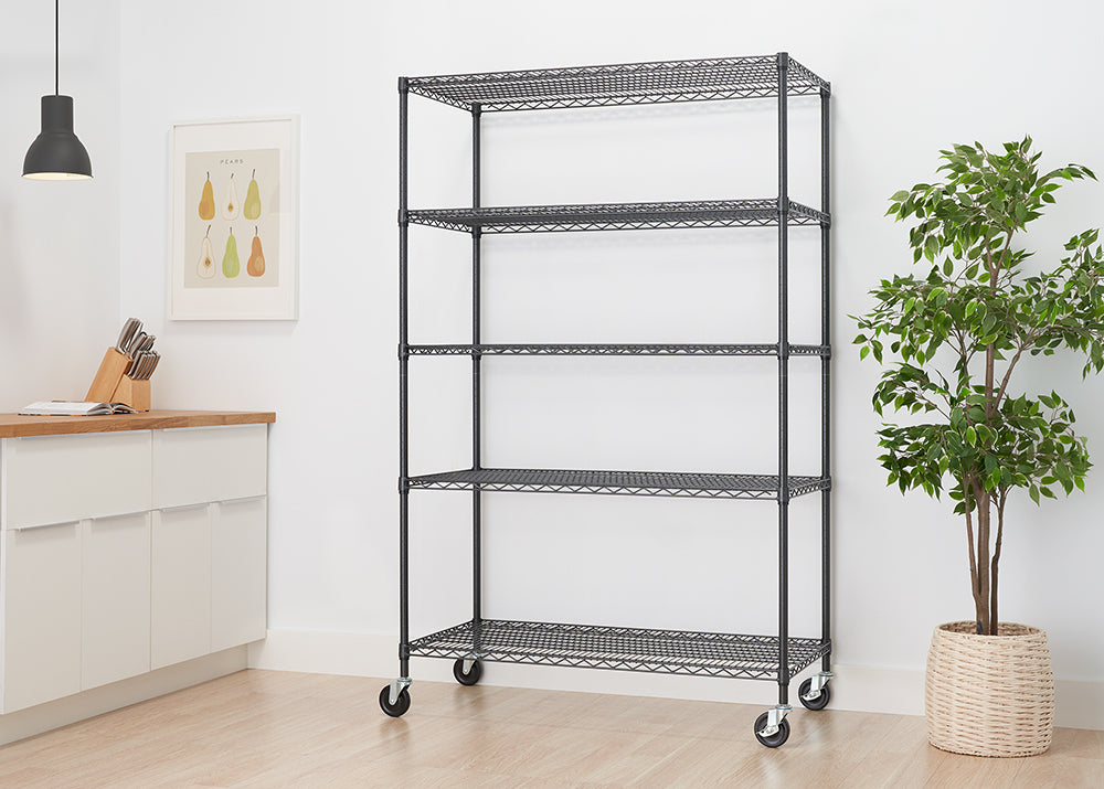 A tall, five-shelf wire shelving unit with a black finish is shown in a modern kitchen. The unit has wheels, suggesting it is mobile, and is empty, waiting to be used.