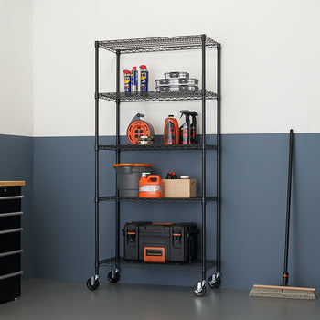 A tall, five-shelf wire shelving unit in black is shown fully loaded with various garage and household items, including tools, cleaning supplies, and storage boxes. The unit is on casters and is sitting on a gray floor against a wall painted with a two-tone design of white and dark blue-gray.